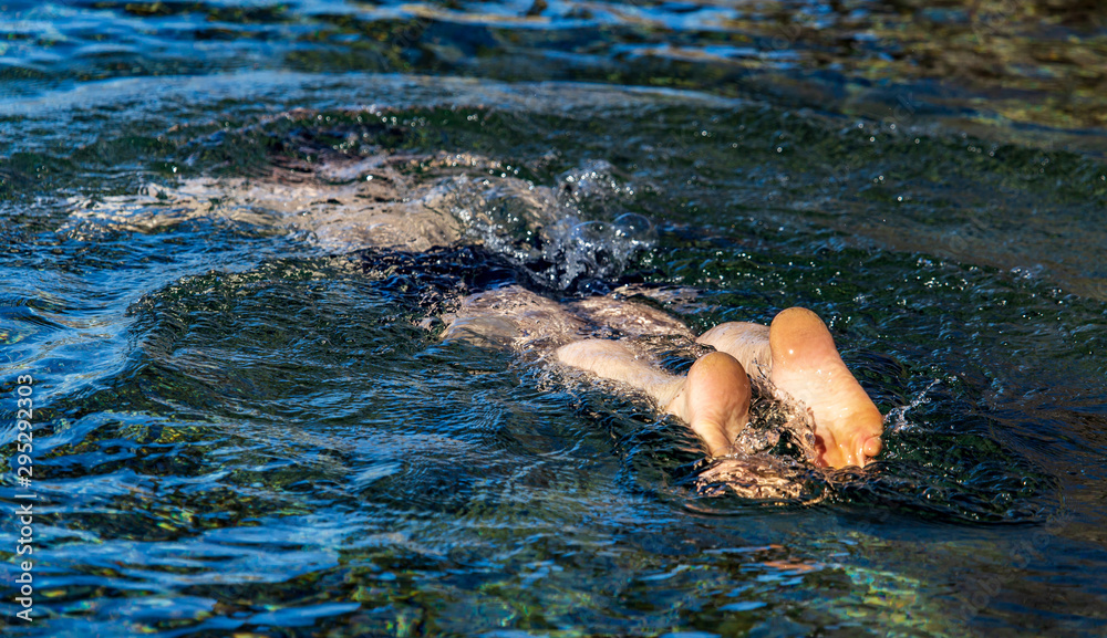 A man swims on the surface of a reservoir