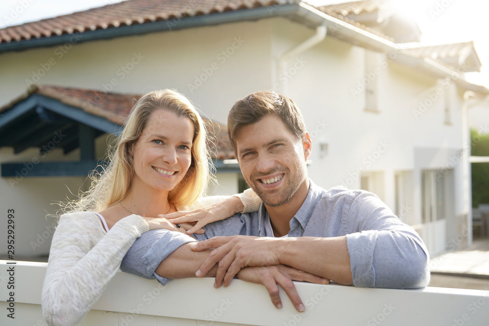 Cheerful couple in front of new house