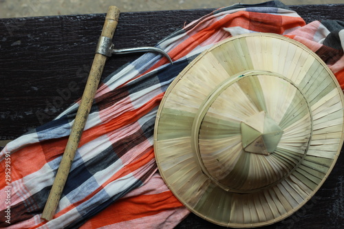 flat lay details showing the tools and colorful clothing and bamboo woven hat of a traditional Northern Thailand Thai Elephant Mahoot trainer, Southeast Asia photo