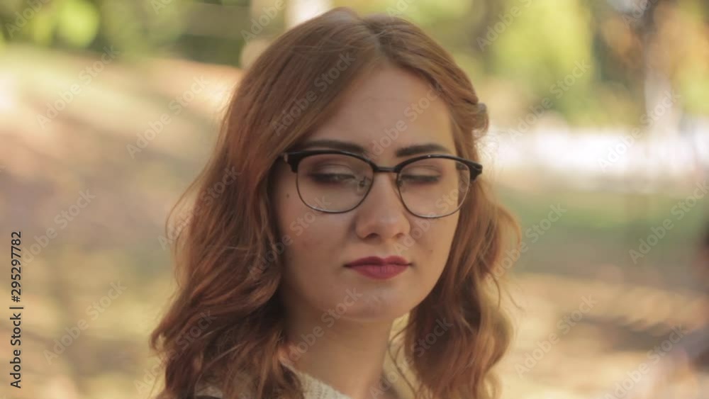Beautiful girl in glasses looking at camera in park Beautiful girl in glasses looking at camera in park