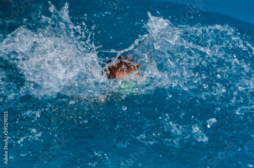 child swims in the water and makes splashes © DmitryDolgikh