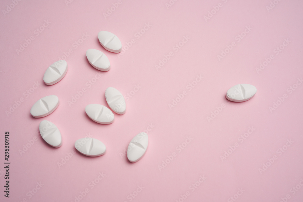 White pills on pink background White pills on pink background