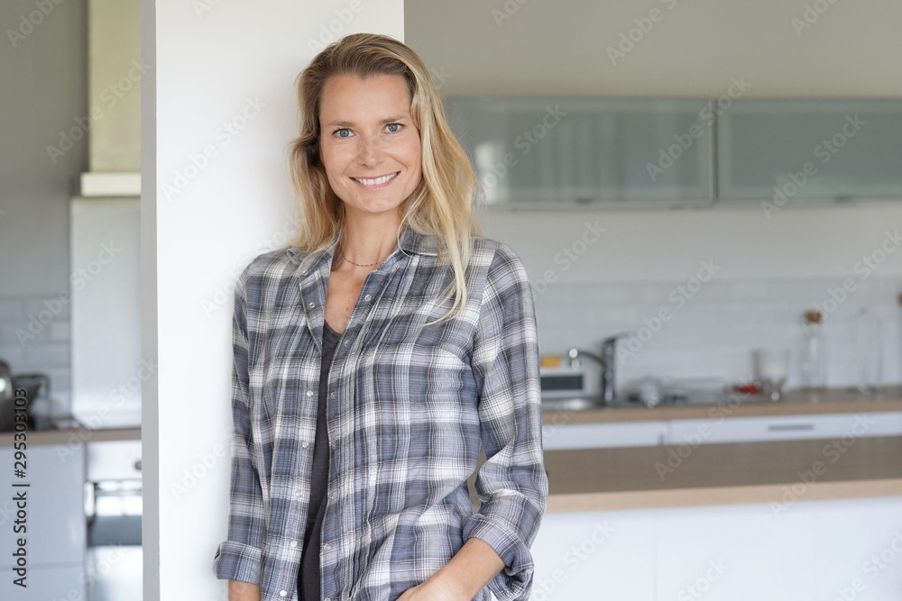 Attractive blond woman standing at home