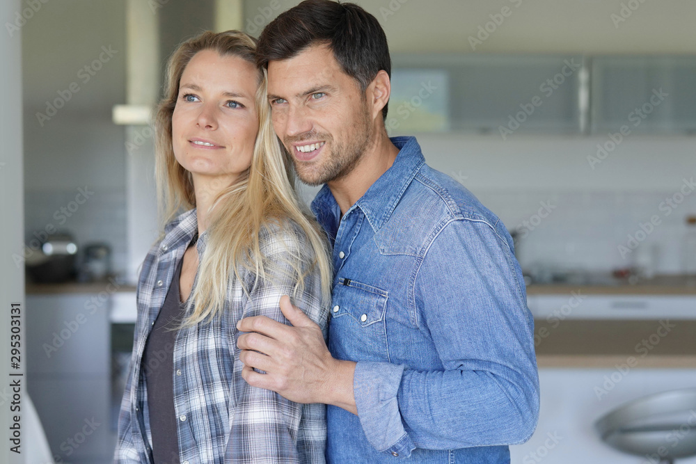 Portrait of cheerful middle-aged couple at home