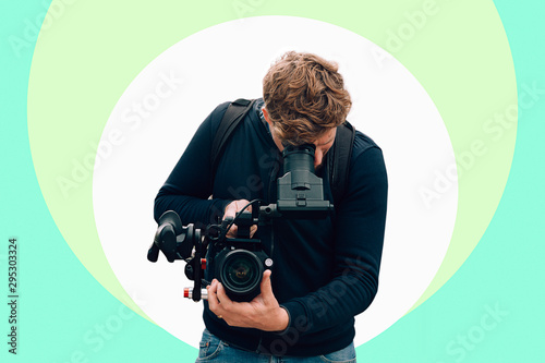 frontal portrait of a cameraman recording with a professional camera against a colorful digital background