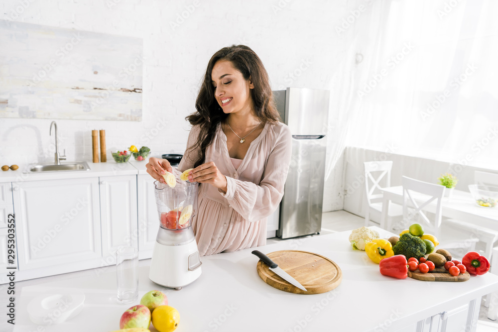 happy pregnant woman putting bananas in blender happy pregnant woman putting bananas in blender