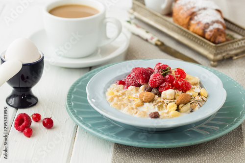 Breakfast Cereal, egg, juice, coffee. Table setting. Healthy tasty breakfast multigrain wholewheat healthy cereals with raspberries, black currants and red currants.