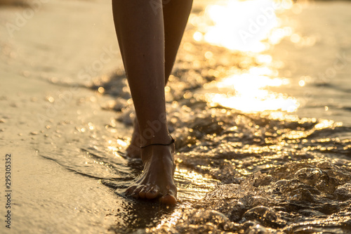 Feet of a girl on the water of the beach
