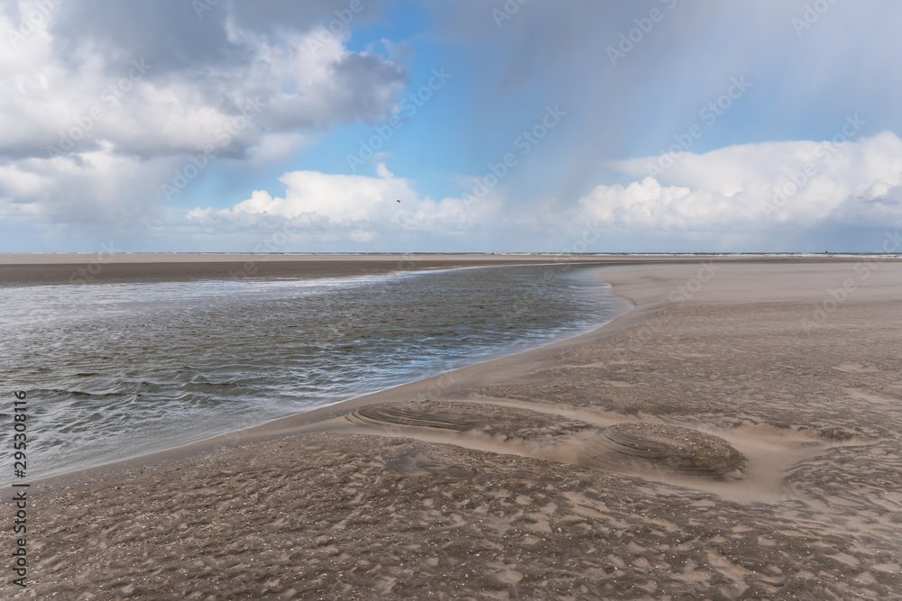 Fototapeta premium Wetterwechsel am Strand mit Wind, Regen und dunkle Wolken am Kijkduin Strand bei Den Haag, Holland, Niederlande