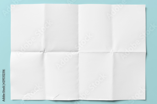 White paper folded in eight, isolated on light blue photo