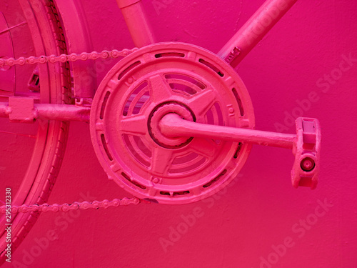 Close up details of a bicycle painted in pink color. pedals. photo