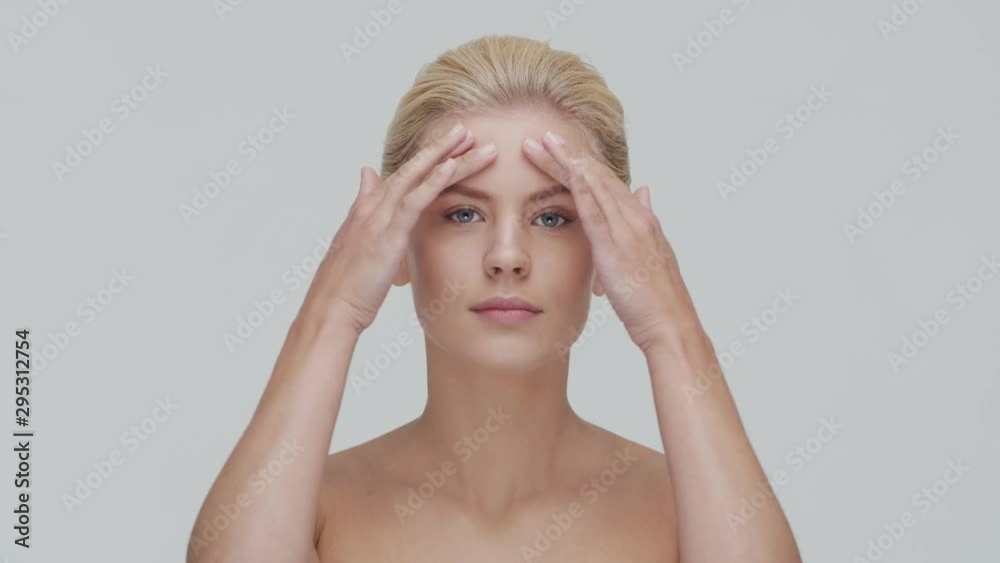 Studio portrait of young, beautiful and natural blond woman applying skin care cream. Face lifting, cosmetics and make-up. Studio portrait of young, beautiful and natural blond woman applying skin care cream. Face lifting, cosmetics and make-up.