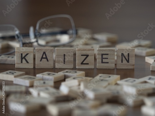 The concept of Kaizen represented by wooden letter tiles photo