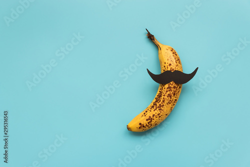 Bad banana with black paper mustache. Sexually transmitted diseases concept. photo