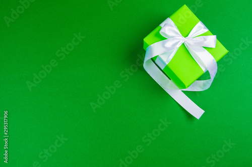 Decorated gift box on a green background, flat lay top view