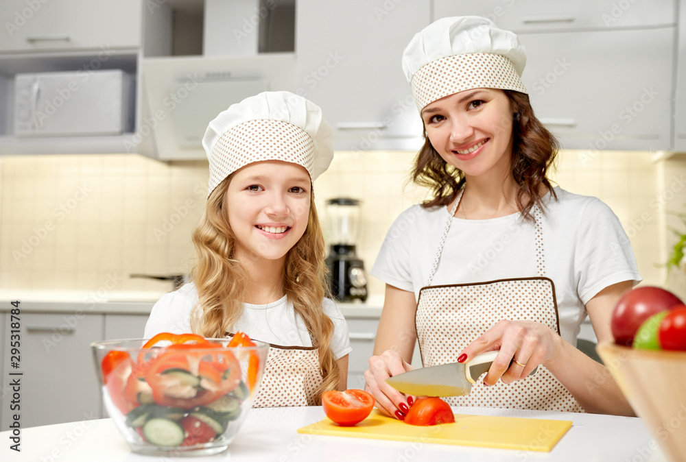 Cheerful family looking at camera while cooking salad Cheerful family looking at camera while cooking salad