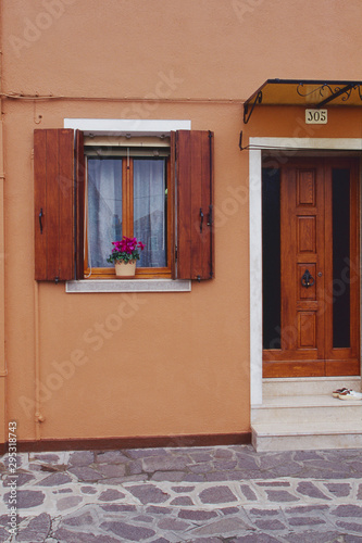 ピーチ色の家の入り口と花
