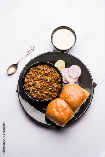 Kheema / keema Pav or Khima Paav is a spicy curry dish made up of minced chicken or lamb cooked with onion, tomatoes, served with buns. selective focus