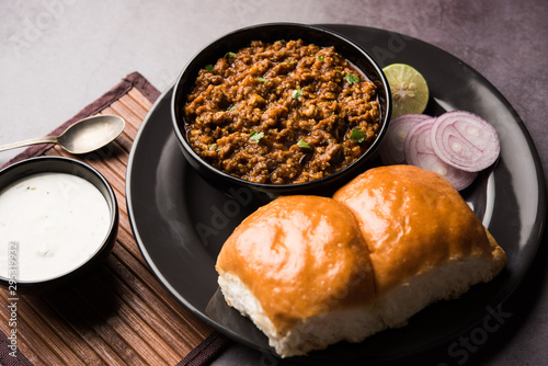 Kheema / keema Pav or Khima Paav is a spicy curry dish made up of minced chicken or lamb cooked with onion, tomatoes, served with buns. selective focus