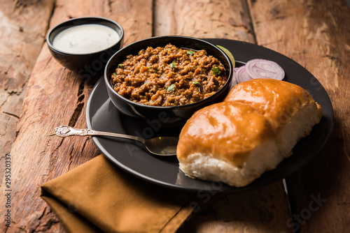 Kheema / keema Pav or Khima Paav is a spicy curry dish made up of minced chicken or lamb cooked with onion, tomatoes, served with buns. selective focus