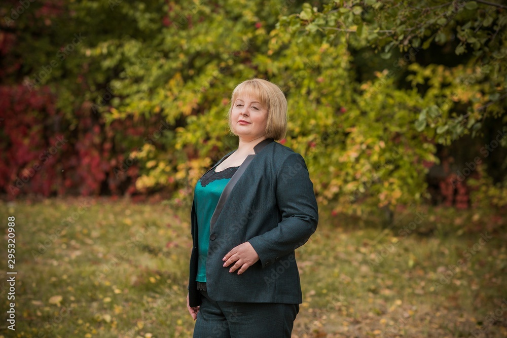 Beautiful mature fashionable woman on a walk in the city. Season time. A nice middle aged plus size woman standing on the street. Plump women lifestyle Beautiful mature fashionable woman on a walk in the city. Season time. A nice middle aged plus size woman standing on the street. Plump women lifestyle