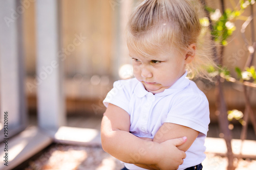 Little girl with sad expression outside. Sad little blonde girl