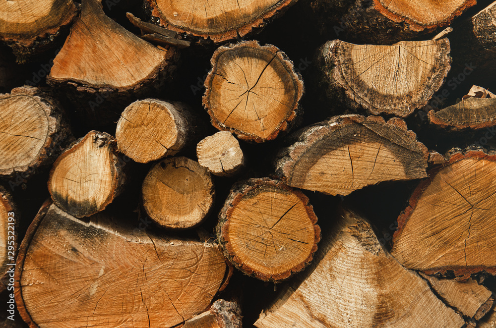 Naklejka premium Drewno opałowe ściany, tło dzienniki suche posiekane drewno opałowe w stos. Zbieranie drewna opałowego na zimę. Zbieranie drewna opałowego na zimę.