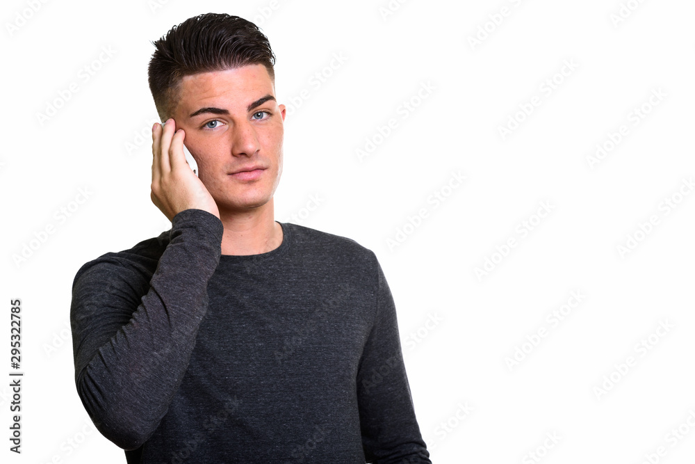 Studio shot of young handsome man talking on mobile phone Studio shot of young handsome man talking on mobile phone