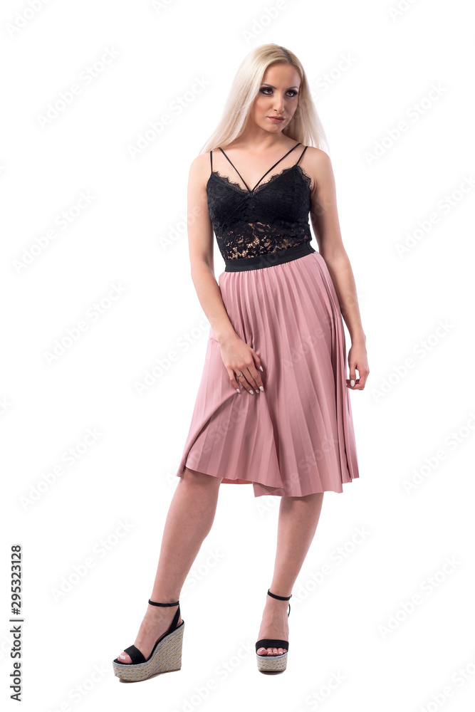 Confident seductive cocky young woman raising or lifting skirt looking away. Full body isolated on white background. Confident seductive cocky young woman raising or lifting skirt looking away. Full body isolated on white background.