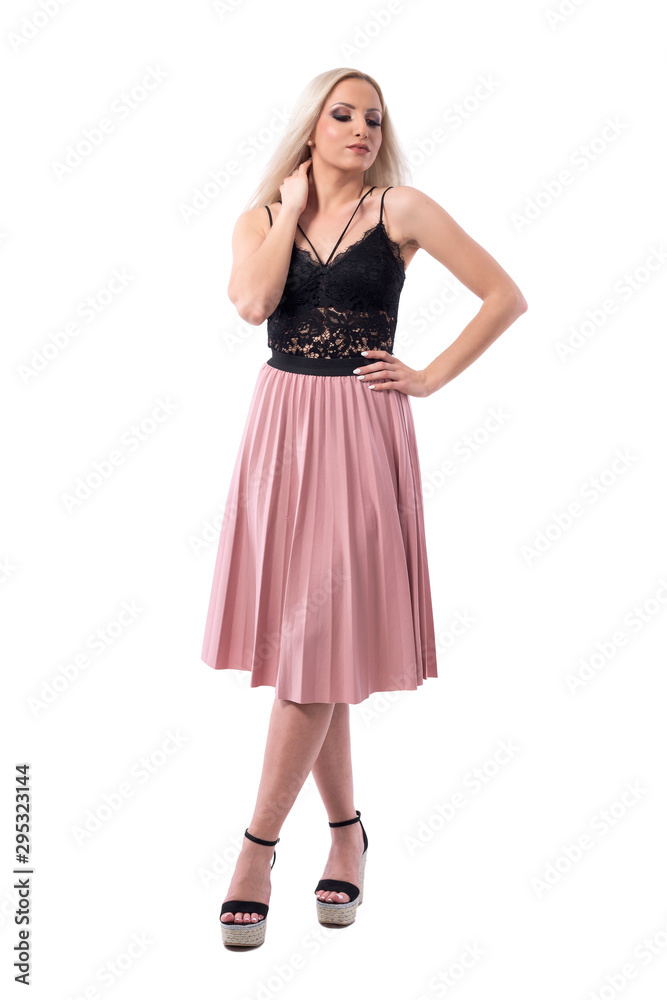 Blonde beauty woman fashion model in skirt and lace top posing with hand on neck looking down. Full body isolated on white background. Blonde beauty woman fashion model in skirt and lace top posing with hand on neck looking down. Full body isolated on white background.
