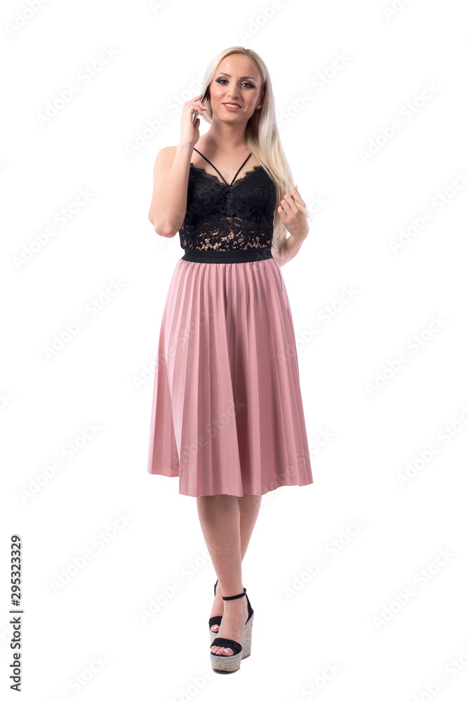 Happy confident classy blonde beauty woman walking on listening phone call looking at camera. Full body isolated on white background. 