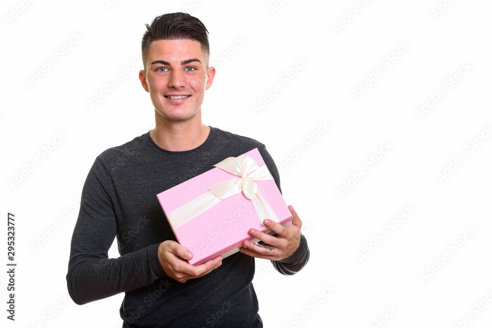 Studio shot of young happy handsome man smiling while holding gi