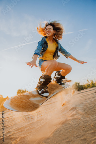 Tourist Sandboarding sexy girl In the Desert Man jumps in and does the trick