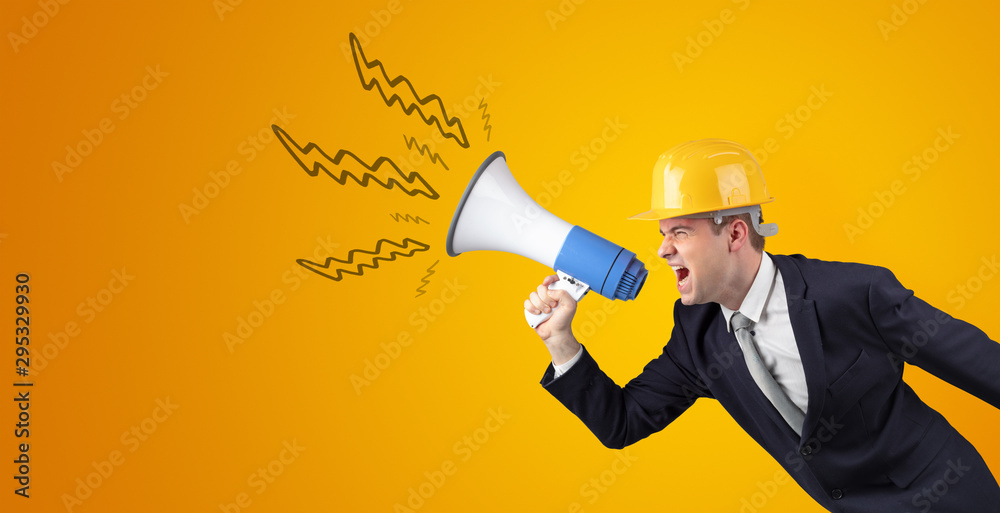 Fototapeta premium Young architect constructor yelling with megaphone and copyspace