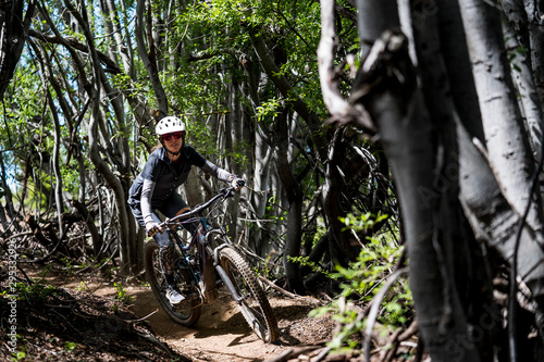 female mountain biker in tree grove