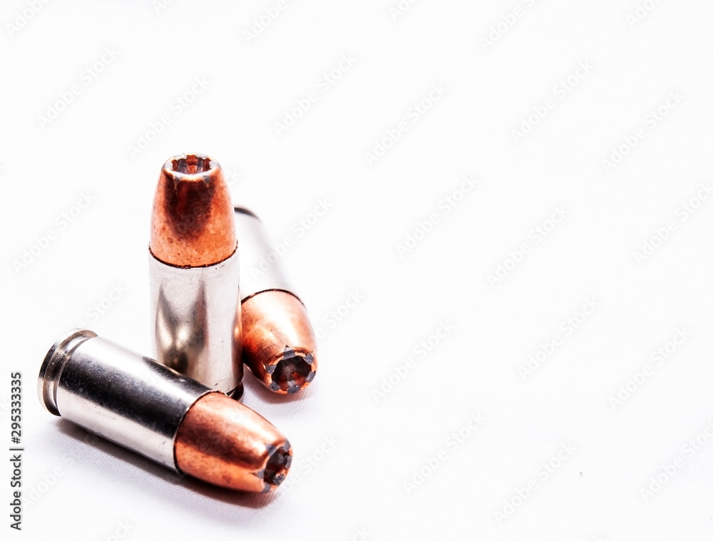 Three 9mm hollow point bullets on a white background with added room for text Three 9mm hollow point bullets on a white background with added room for text