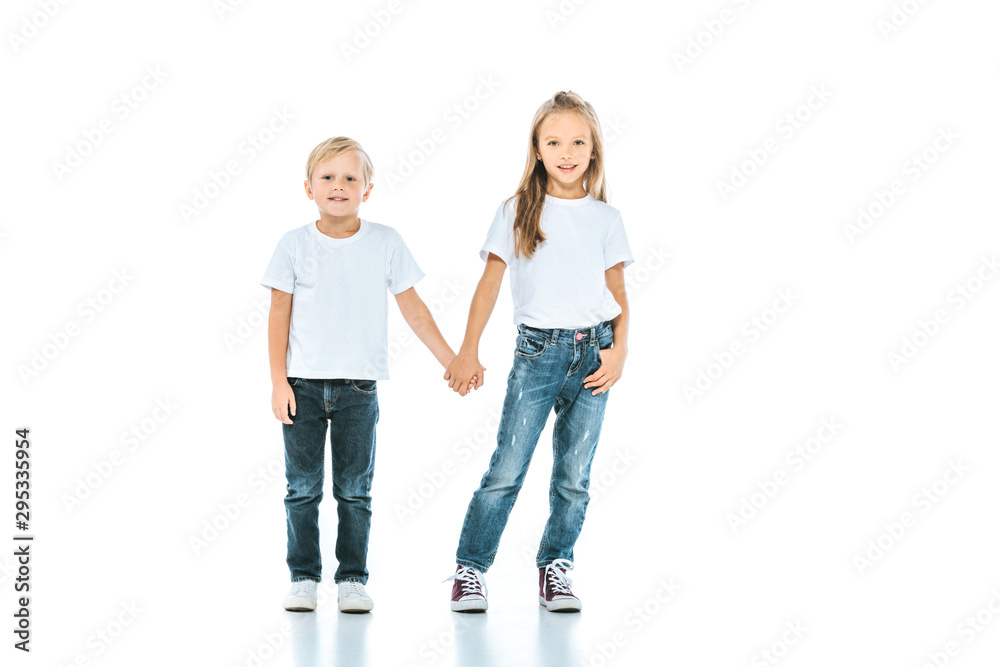 cute kids holding hands and standing in blue jeans on white cute kids holding hands and standing in blue jeans on white