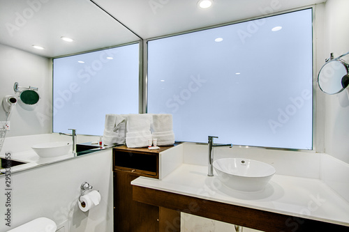 modern spacious white bathroom with wooden cabinet © selenedasilva