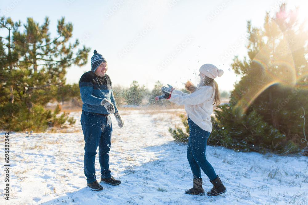 Loving couple play snowballs in winter in the forest. Throw each other snow. Laugh and have a good time Loving couple play snowballs in winter in the forest. Throw each other snow. Laugh and have a good time