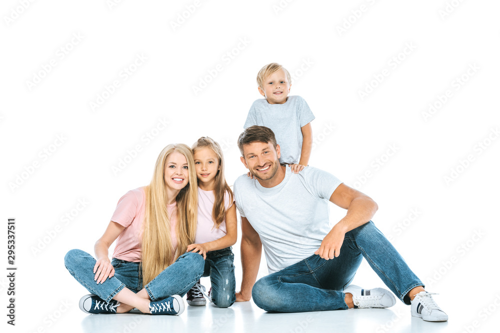 happy parents and children in blue denim jeans sitting on white happy parents and children in blue denim jeans sitting on white