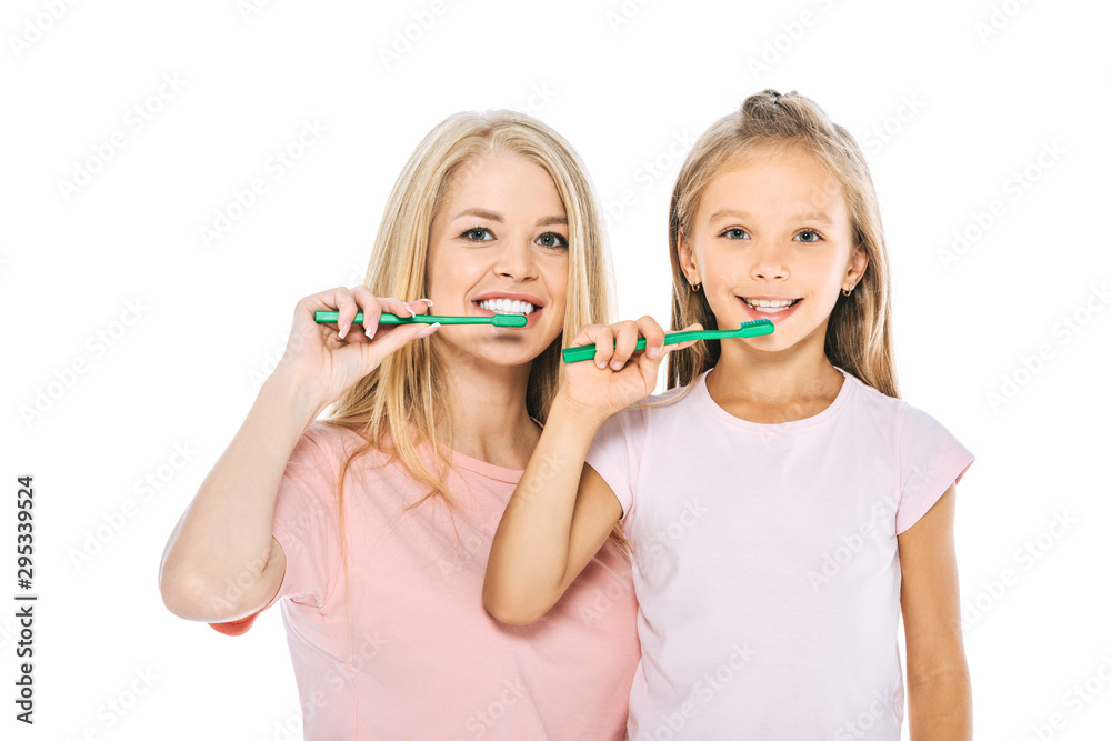 happy mother and daughter brushing teeth and looking at camera isolated on white happy mother and daughter brushing teeth and looking at camera isolated on white