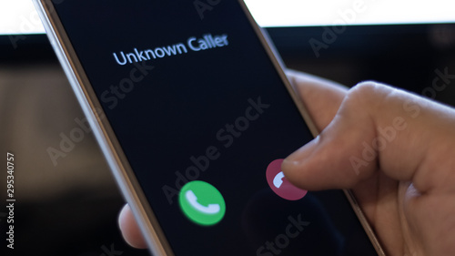 Unknown caller. A man holds a phone in his hand and thinks to end the call. Incoming from an unknown number at night. Incognito or anonymous