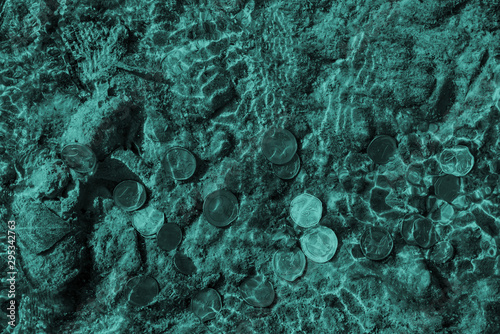 blue cold image of european union coins under the flowing water of the river,view directly above,close-up