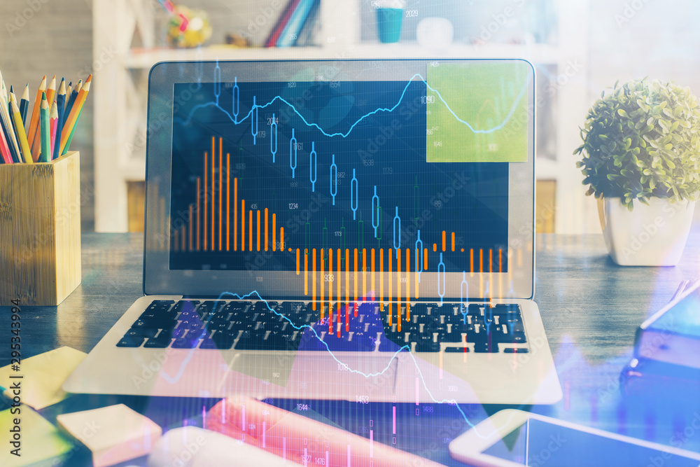 Financial graph colorful drawing and table with computer on background. Double exposure. Concept of international markets. Financial graph colorful drawing and table with computer on background. Double exposure. Concept of international markets.