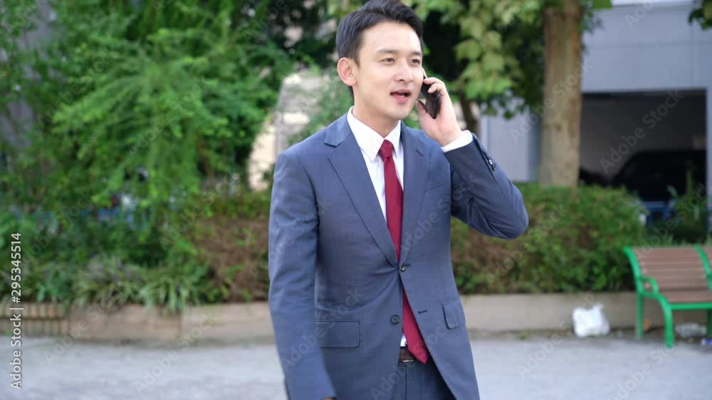 外でスマートフォンを使うビジネスマン 外でスマートフォンを使うビジネスマン