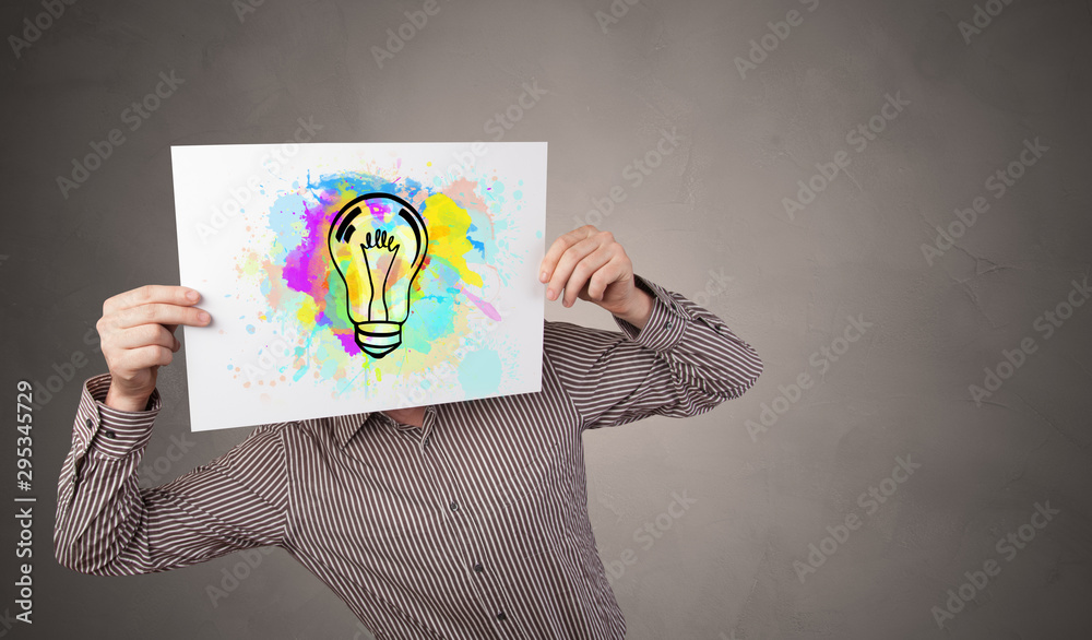 Person holding a paper with a drawn colorful idea concept Person holding a paper with a drawn colorful idea concept