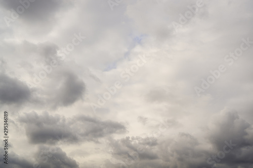 Autumn sky with gray heavy clouds. where no light blue sky looks. Horizontal orientation.