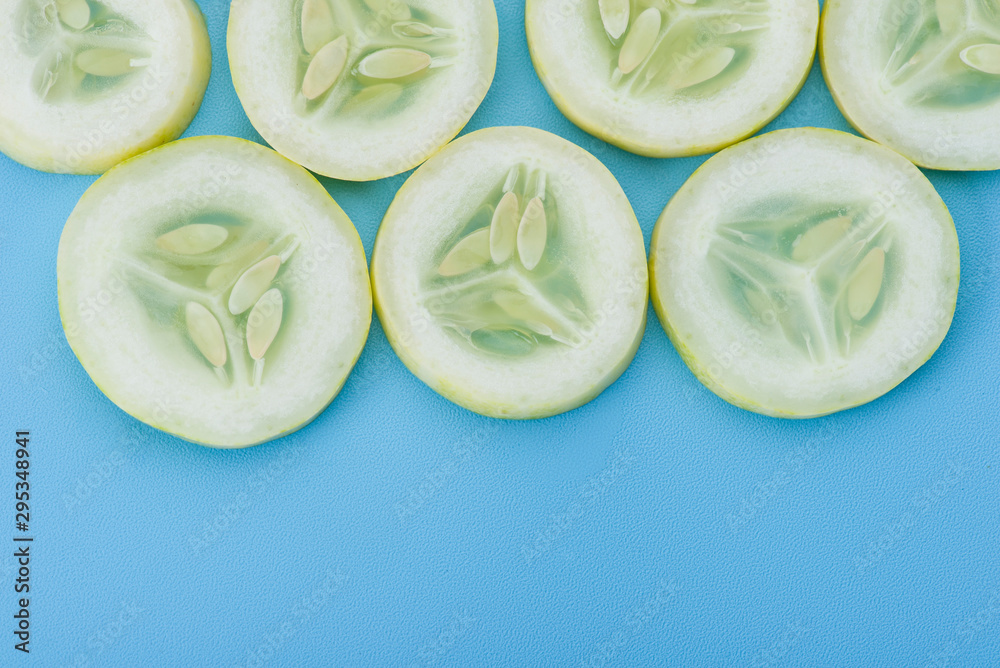 Fototapeta premium Close up fresh slice cucumber on blue