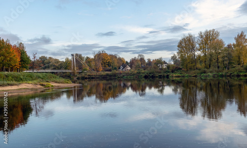 autumn landscape with river, bridge and beautiful colorful trees, river Gauja, Valmiera, Latvia