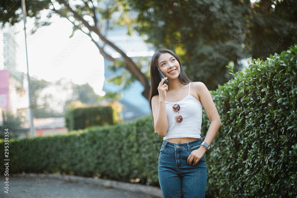 Young woman walking and talking with smart phone on a city street Young woman walking and talking with smart phone on a city street